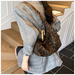 Detail der Leopard-Hobo-Tasche mit Holzperlen-Anhänger und Leder-Schultergurt