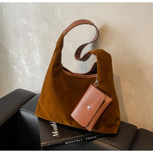 Detail of dark brown suede tote bag with a small matching coin purse on a leather handle