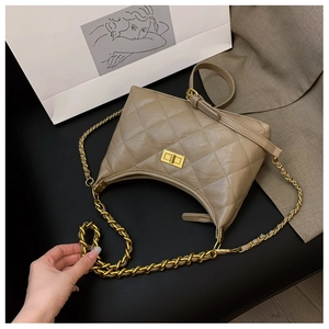 Detail of khaki quilted leather crossbody bag with gold chain strap and elegant turn-lock closure