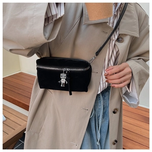 Close-up of black suede crossbody bag with silver robot charm and metal zipper