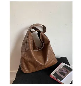 Detail shot of the brown woven texture on the large retro shoulder bag for women