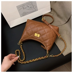 Detail of brown quilted faux leather bag featuring a gold twist lock and chain strap