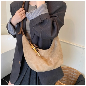 Detail der Wildleder-Hobo-Tasche mit bunten Holzperlen und geknotetem Lederriemen