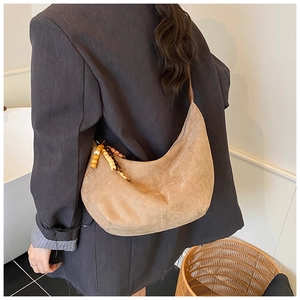 Braune Wildleder Halbmondtasche mit Holzperlen-Detail getragen als Schultertasche