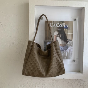 Détail de la texture en cuir PU tressé marron sur un grand sac cabas fourre-tout