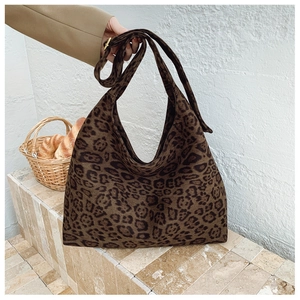 Close-up of leopard print hobo bag with wide shoulder strap in a French style setting