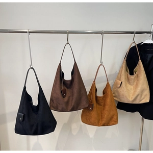 Macro detail of large suede hobo bags in four colors with matching charm pouches