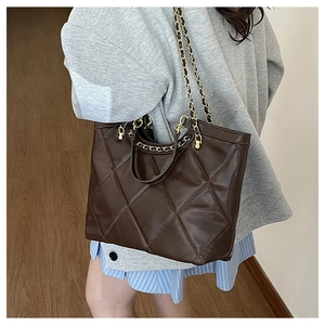Vue détaillée du sac cabas matelassé marron foncé avec chaîne dorée et cuir PU souple de qualité