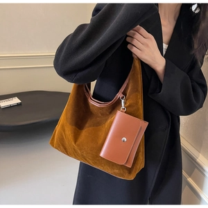 Brown suede hobo bag with a matching small coin purse shown on a model's shoulder