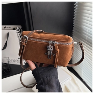 Detail of suede mini crossbody bag featuring dual zippers and metal robot charm