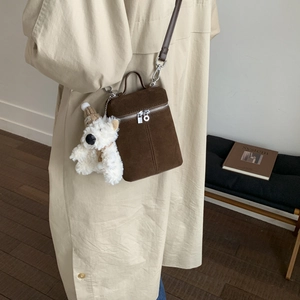 Detail der vintage braunen mattierten Umhängetasche mit süßem Teddybär-Plüschanhänger