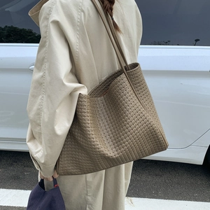 Vue latérale du grand sac cabas tressé kaki montrant sa capacité et ses longues anses