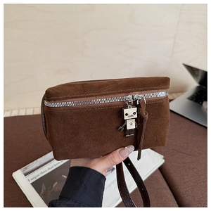 Detailed view of brown suede crossbody bag with vintage silver robot charm and zipper