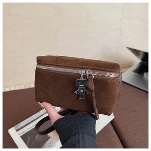 Detailed view of brown suede crossbody bag featuring a unique robot metal pendant zipper