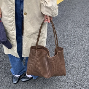 Vue détaillée d'un sac cabas marron en cuir tressé avec des fines lanières d'épaule