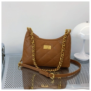 Detail view of the brown quilted handbag with a gold chain strap and turn-lock closure