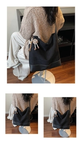 Detail of black large capacity tote bag featuring leather patchwork and plush charm