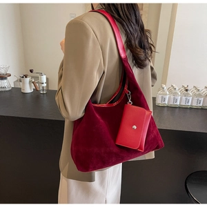Detail of burgundy hobo bag with suede texture and matching leather accessory pouch