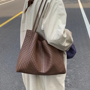 Détail de la texture en cuir tressé marron d'un grand sac cabas rétro pour un style élégant