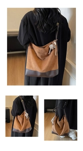 Close-up of brown suede tote bag featuring leather patchwork and decorative tassels
