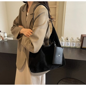 Detail of vintage black suede tote bag with matching pouch shown in a cafe setting