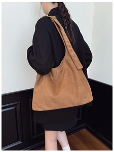 Brown matte suede hobo bag with wide shoulder strap showing large capacity and texture