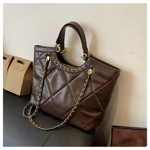 Gros plan sur un sac cabas marron matelassé avec cuir brillant et bandoulière chaîne