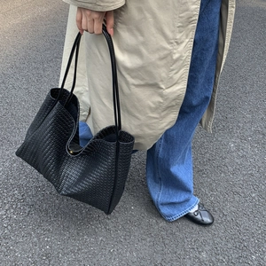 Gros plan détaillé montrant la texture tissée et le matériau souple du grand sac cabas noir