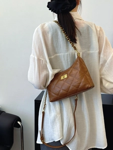 Brown quilted crossbody bag with gold chain strap and turn-lock on a model