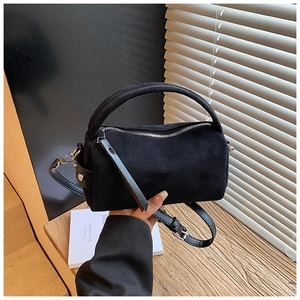 Dettaglio borsa bauletto in camoscio nero con zip argento e manico spesso da donna
