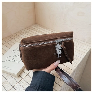 Detail of vintage brown suede crossbody bag with a robot charm and silver zipper