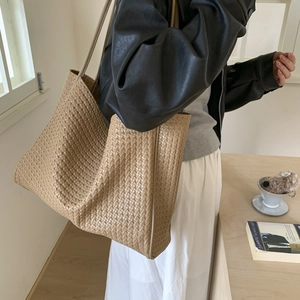 Gros plan sur la texture en cuir tissé du sac fourre-tout chameau porté épaule