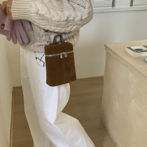 Detailaufnahme der braunen Wildleder-Beuteltasche mit silbernen Metallteilen und Griff