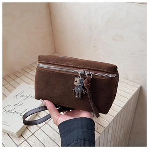 Detailed close-up of brown suede crossbody bag featuring a unique robot zipper puller