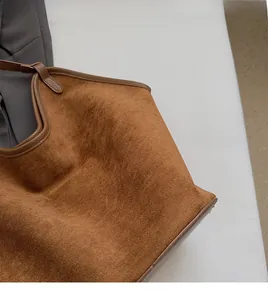 Detail of soft brown suede tote bag with durable leather edges and fine matte texture