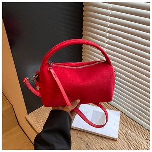 Dettaglio della borsa a cilindro rossa in pelle opaca vintage con cerniera e manico