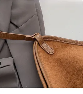 Close-up of litchi texture leather and precision stitching on a brown tote bag