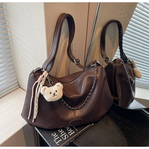Detail der braunen Vintage Hobo Tasche mit Silberkette und weißem Teddybär Anhänger