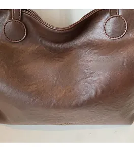 Close-up of soft brown faux leather texture and reinforced stitching on tote bag
