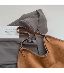 Macro detail of brown suede and smooth leather texture on a large tote bag