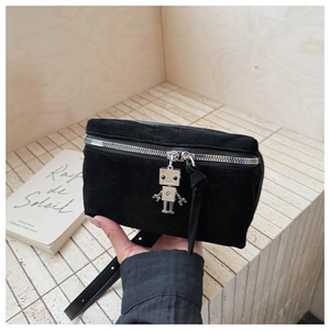 Detail of black suede crossbody bag with silver zipper and robot charm pendant