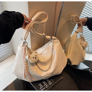 Detail der weißen PU-Ledertasche mit Silberkette und süßem Teddybär-Anhänger
