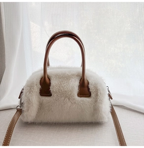Detail of white faux fur texture with brown leather handle and silver metal buckle