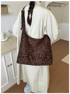 Detailed close-up of brown leopard print hobo bag with adjustable wide shoulder strap