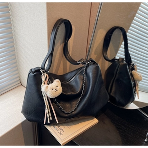 Detailansicht der schwarzen Falten-Tasche aus PU-Leder mit Silberkette und Bärenanhänger