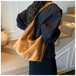 Brown suede tote bag on model showing large capacity and soft vintage hobo style