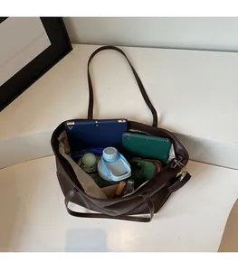 Top view of spacious brown leather tote bag interior showing daily items storage