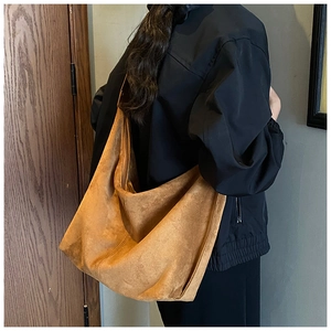 Detailed view of camel suede tote bag with metal zipper and comfortable wide shoulder strap