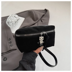 Detail of suede crossbody bag featuring silver zipper and cute robot charm accessory