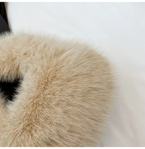 Close-up of premium beige faux fur texture on a soft plush dumpling handbag surface